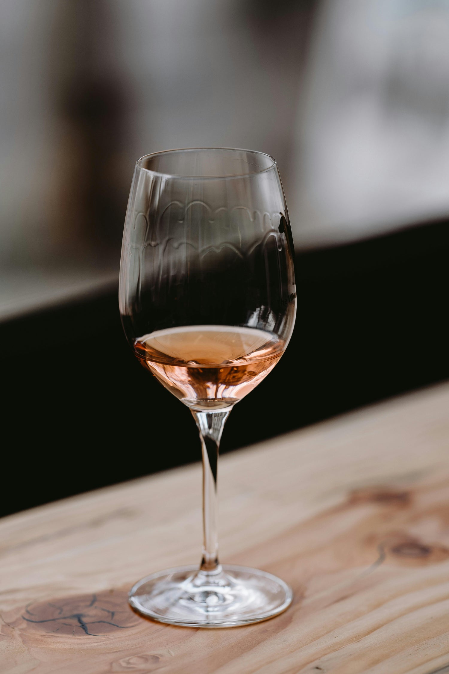 Een glas verfijnde rosé wijn op een houten tafel, symbool voor de kwaliteit en authenticiteit van Kraijenoord's Italiaanse wijnen.