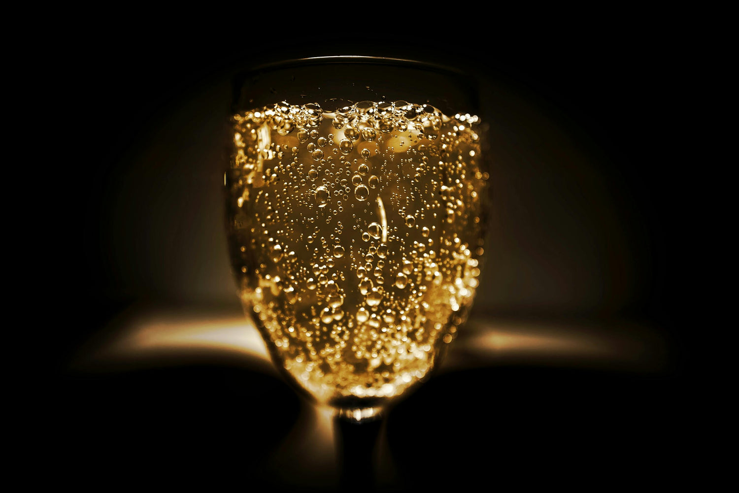 Close-up van een glas mousserende wijn met sprankelende bubbels, perfect voor feestelijke momenten en bijzondere gelegenheden.