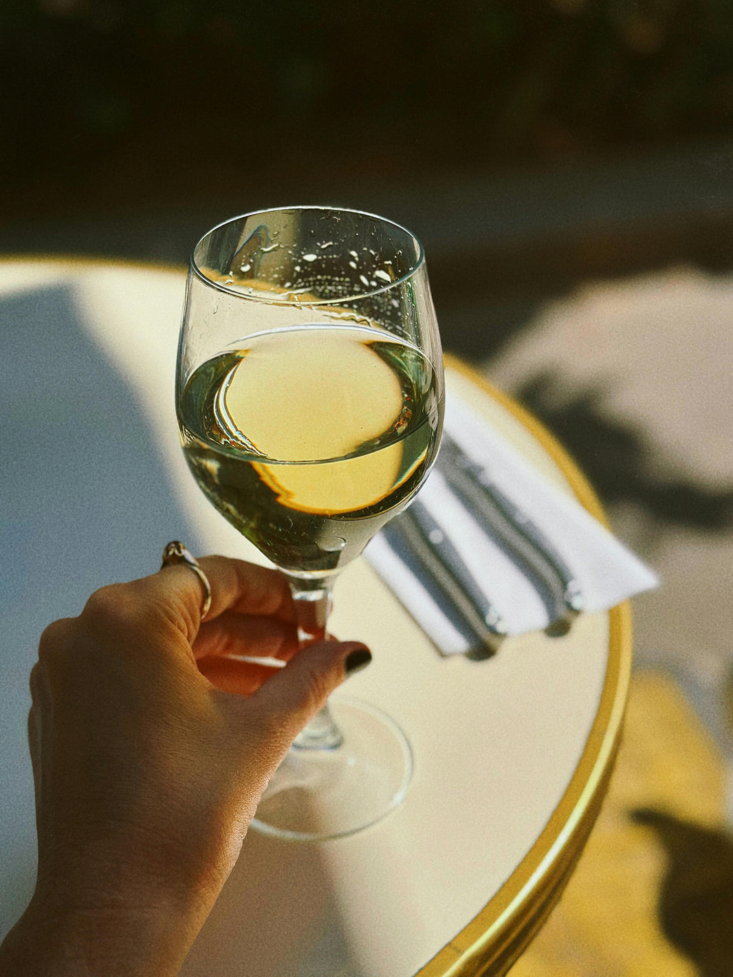 Glas witte wijn op een tafel bij zonsondergang, perfect voor ontspannen avonden.